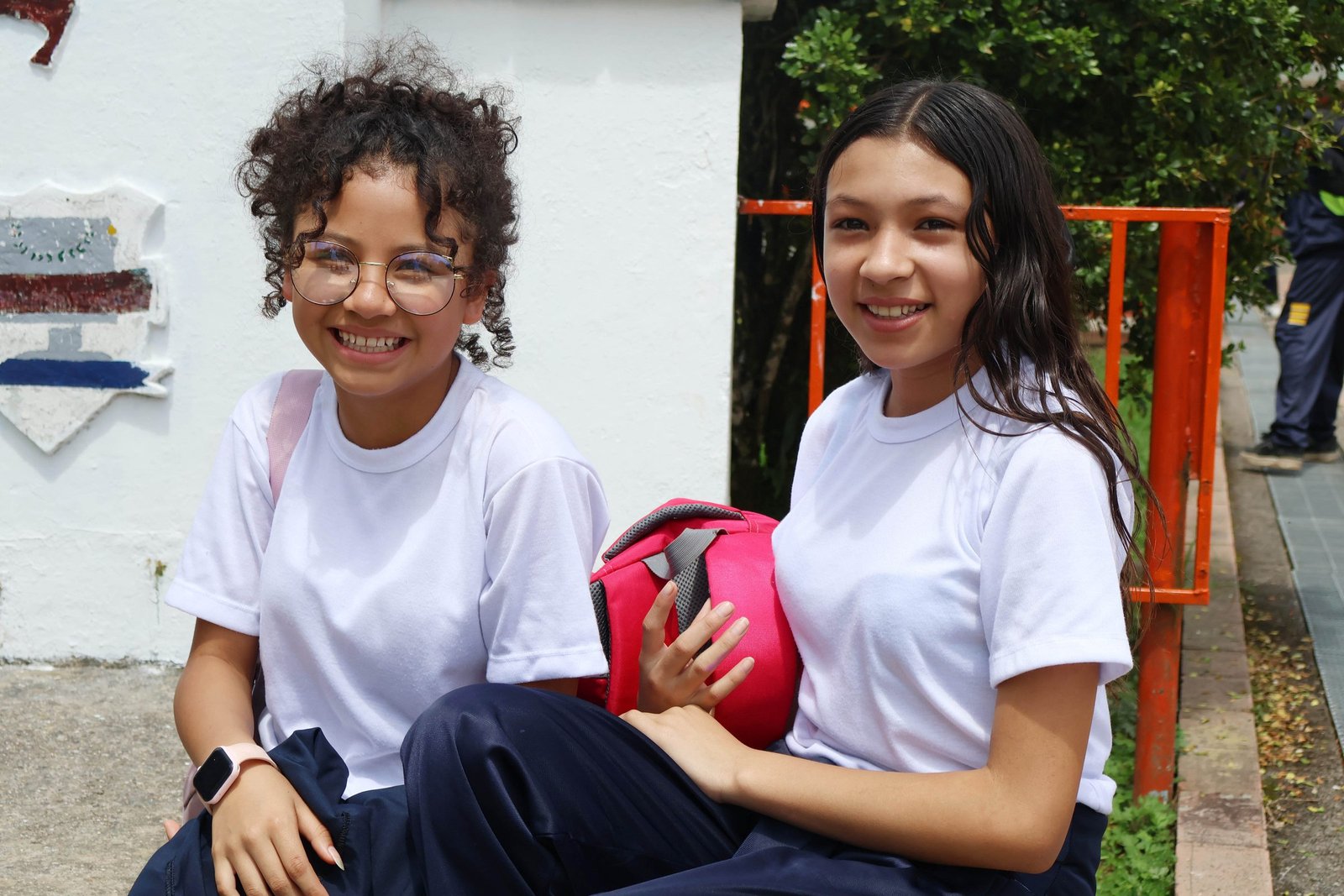Dos estudiantes sonriendo en el patio del colegio